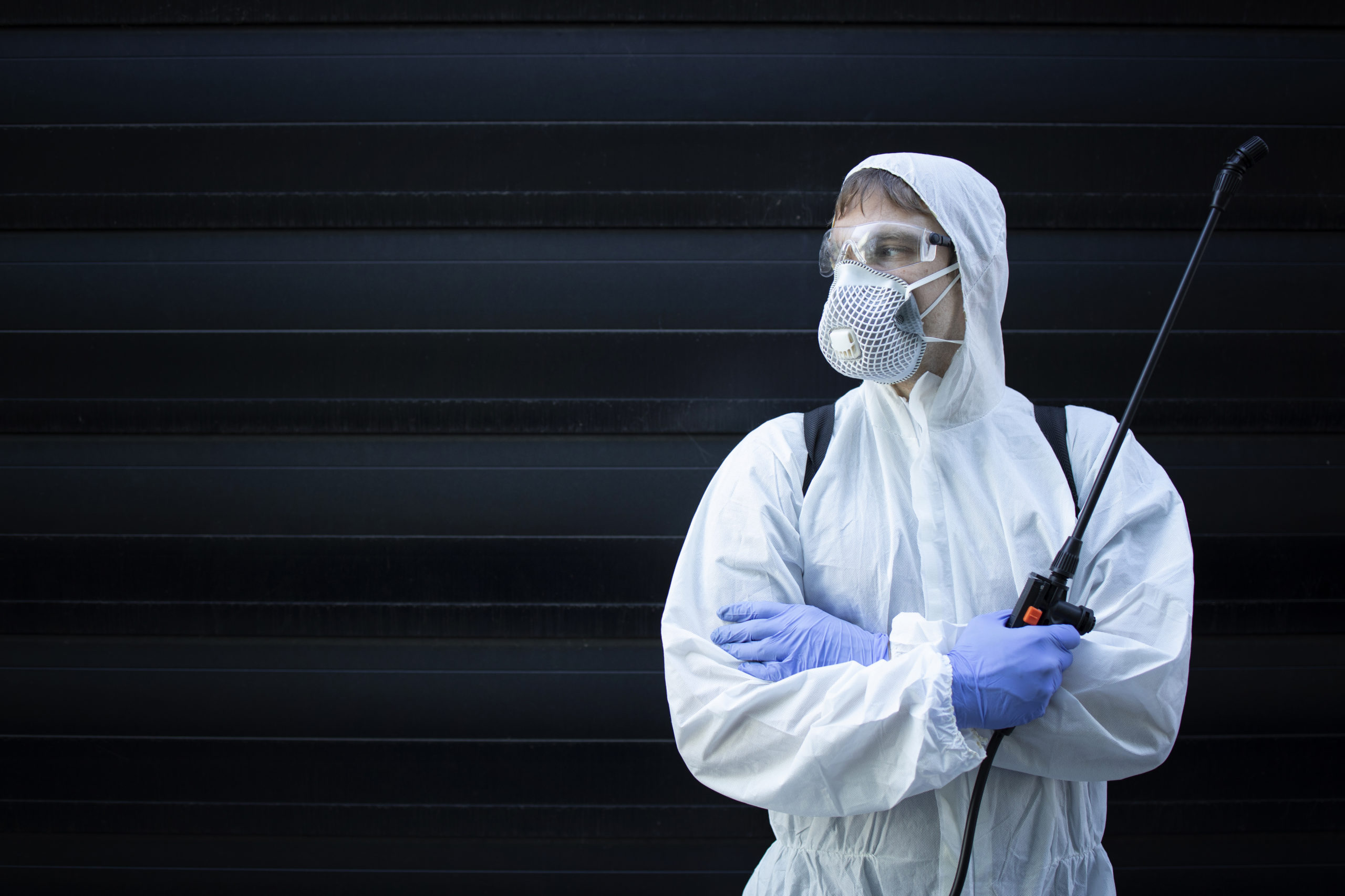 Portrait of professional exterminator holding sprayer with chemicals for pest control.